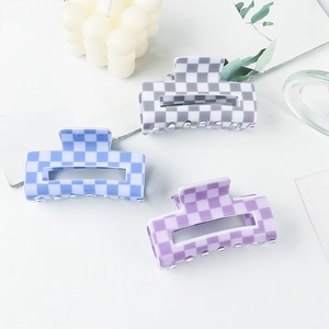Trois grandes pinces à cheveux à motif damier dans les tons gris, bleu et violet