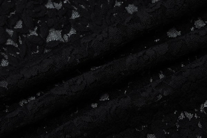 Gros plan sur la dentelle noire élégante avec motifs floraux ajourés et détails raffinés