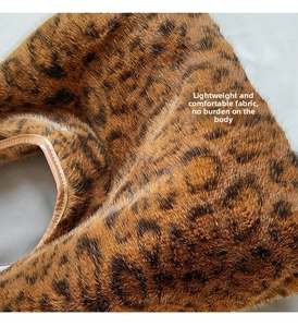 Vue détaillée du tissu pelucheux léopard et des bordures en cuir sur le sac fourre-tout