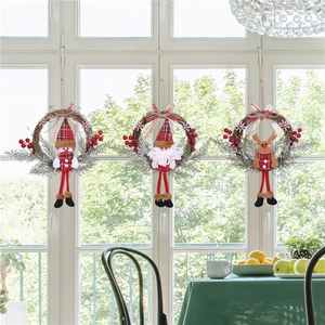 Three Christmas rattan wreaths with Santa, Snowman and Reindeer on a glass window