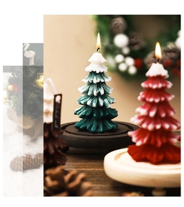 Green, red and brown Christmas tree candles with lit flames on a wooden base