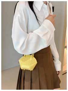 Detail showing a yellow mini jelly bag with geometric texture and gold chain strap