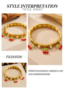 Detail of gold cherry charm bracelet with red enamel and sparkling crystal stones