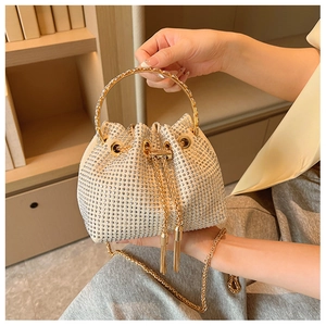 Detail of rhinestone bucket bag with gold ring handle and tassel drawstring closure