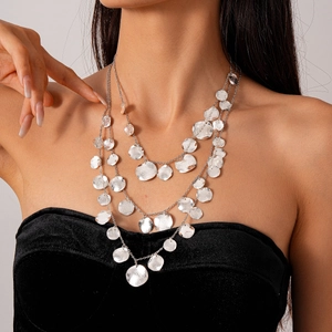 Three-layer silver necklace with hammered geometric discs on a model with black clothing