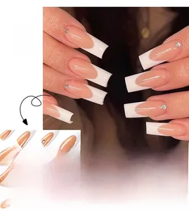 Detail of French tip press-on nails with nude pink base and rhinestone accents