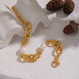 Dettaglio del bracciale a catena d'oro con perle bianche su base in pietra bianca