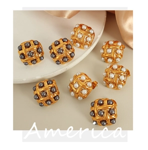 Detail of vintage square woven gold earrings featuring white and dark grey pearls