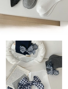 Detail view of cotton grey mid-calf socks with vintage plaid bow knot and soft knit texture