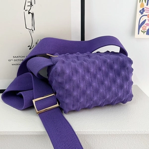 Detail of purple popcorn knit crossbody bag with gold metal buckle and pleated texture