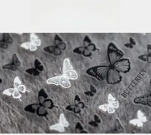 Macro detail of ultra-thin 5D butterfly nail art stickers in black and white tones