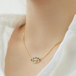 Detailed close-up of golden S925 silver Evil Eye necklace with zircon inlay on model