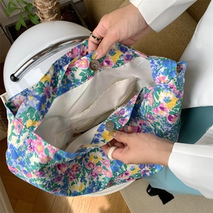 Detail shot of floral canvas tote bag showing inner zipper pocket and magnetic closure