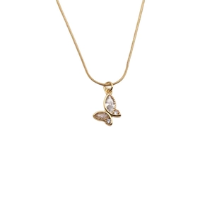 Close-up of golden butterfly pendant necklace with sparkling crystal inlay on snake chain