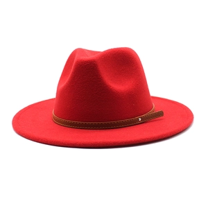 Close-up of bright red wool fedora hat featuring a brown leather band and silver rivet