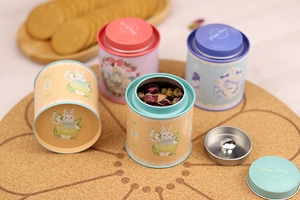 Detail of round tin cans featuring cute rabbit illustrations and double lids for tea