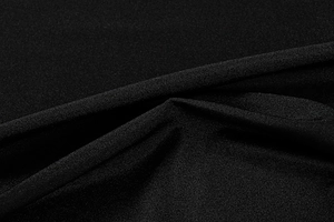 Detailed macro view of black satin fabric with elegant folds and smooth drape texture