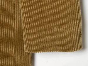 Detail shot of yellow brown corduroy fabric texture and sleeve cuff stitching detail