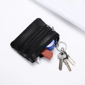 Close-up of three-layer black litchi leather coin purse with silver zippers and keys