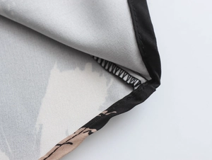 Close-up of high-quality fabric stitching and printed pattern with black piping detail
