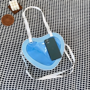 Blue heart-shaped ita bag with a clear window and a smartphone inside for size reference