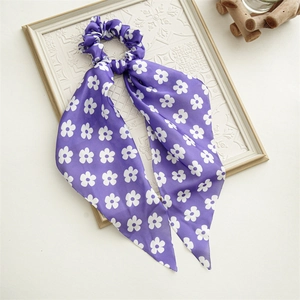 Detail of floral printed periwinkle blue satin scarf scrunchie on a white frame