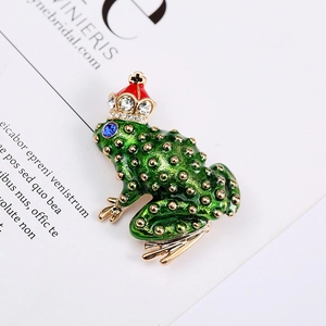 Close-up of green enamel frog prince brooch with crown and sparkling zircon details