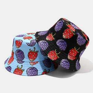 Detail of strawberry and berry print patterns on reversible cotton sun hats