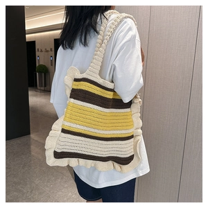 Handmade striped crochet tote bag with ruffles and long strap shown on model's shoulder