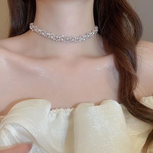 Detailed close-up of a silver zircon and pearl necklace choker on a woman's collarbone