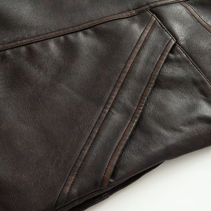Detailed macro view of dark brown leather jacket with intricate reinforced stitching