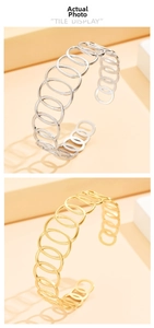 Detail of interlocking hollow oval bangles in polished gold and silver finishes