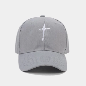Detailed close-up of white cross embroidery on light gray cotton twill baseball cap