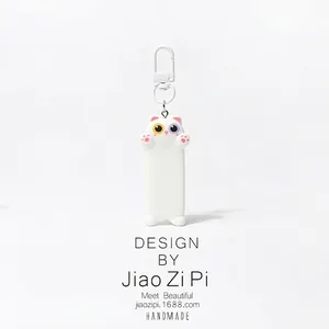 Close-up of white cat keychain with heterochromia eyes and pink paw pads detail