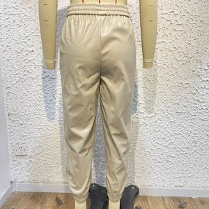 Dettaglio dei pantaloni jogger beige in ecopelle con vita alta elastica e trama posteriore