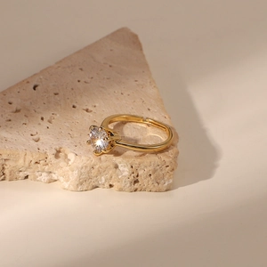 Detail of 18K gold-plated ring featuring a clear zircon stone on a rustic stone texture