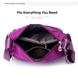 Detailed interior of purple nylon shoulder bag showing spacious multi-layer compartments