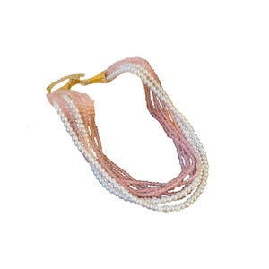Bohemian multilayer necklace with pink beads and white pearls on a gold metal chain