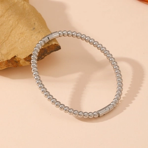 Detailed macro view of polished silver ball bead bracelet with secure clasp on stone base