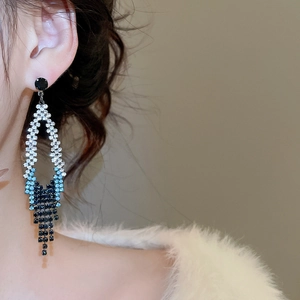 Gros plan de boucles d'oreilles à pampilles en strass avec dégradé bleu brillant