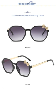 Detail of polygonal black frames with gold bow accents and gradient grey lenses