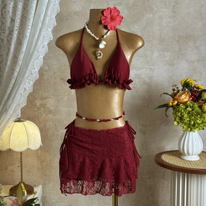 Detail view of burgundy bikini with ruffled hem and matching lace mesh skirt set