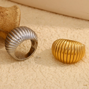 Vue détaillée des bagues croissant plaquées or 18 carats et argent sur fond texturé