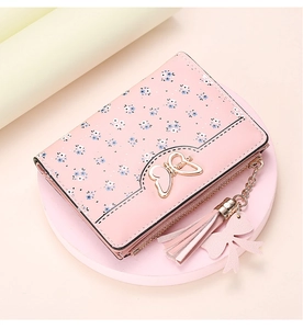 Close-up of pink floral small wallet with golden butterfly buckle and tassel details