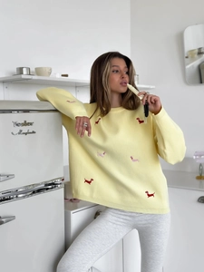 Detail of dachshund embroidery on light yellow knit sweater with ribbed cuffs for women
