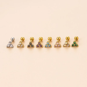 Macro shot of stainless steel cartilage studs with multi-color zircon stones in gold finish