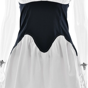 Close-up detail of the waist seam on a black and white patchwork deep V-neck dress