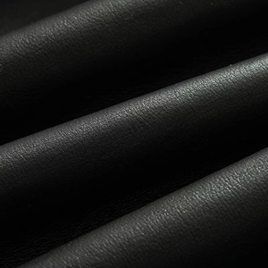 Primer plano del chaleco de cuero negro mostrando el grano natural y la textura suave