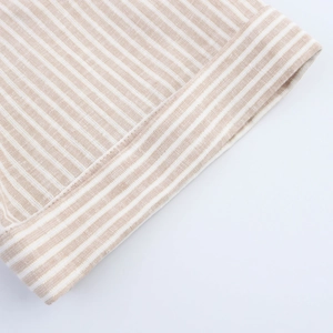 Detailed macro view showing beige and white striped fabric texture and clean stitched hem