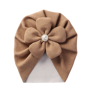 Close-up of khaki cashmere baby hat featuring soft knit flower with a central pearl button